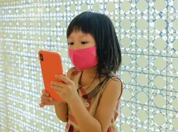 little girl holding phone with orange phone case