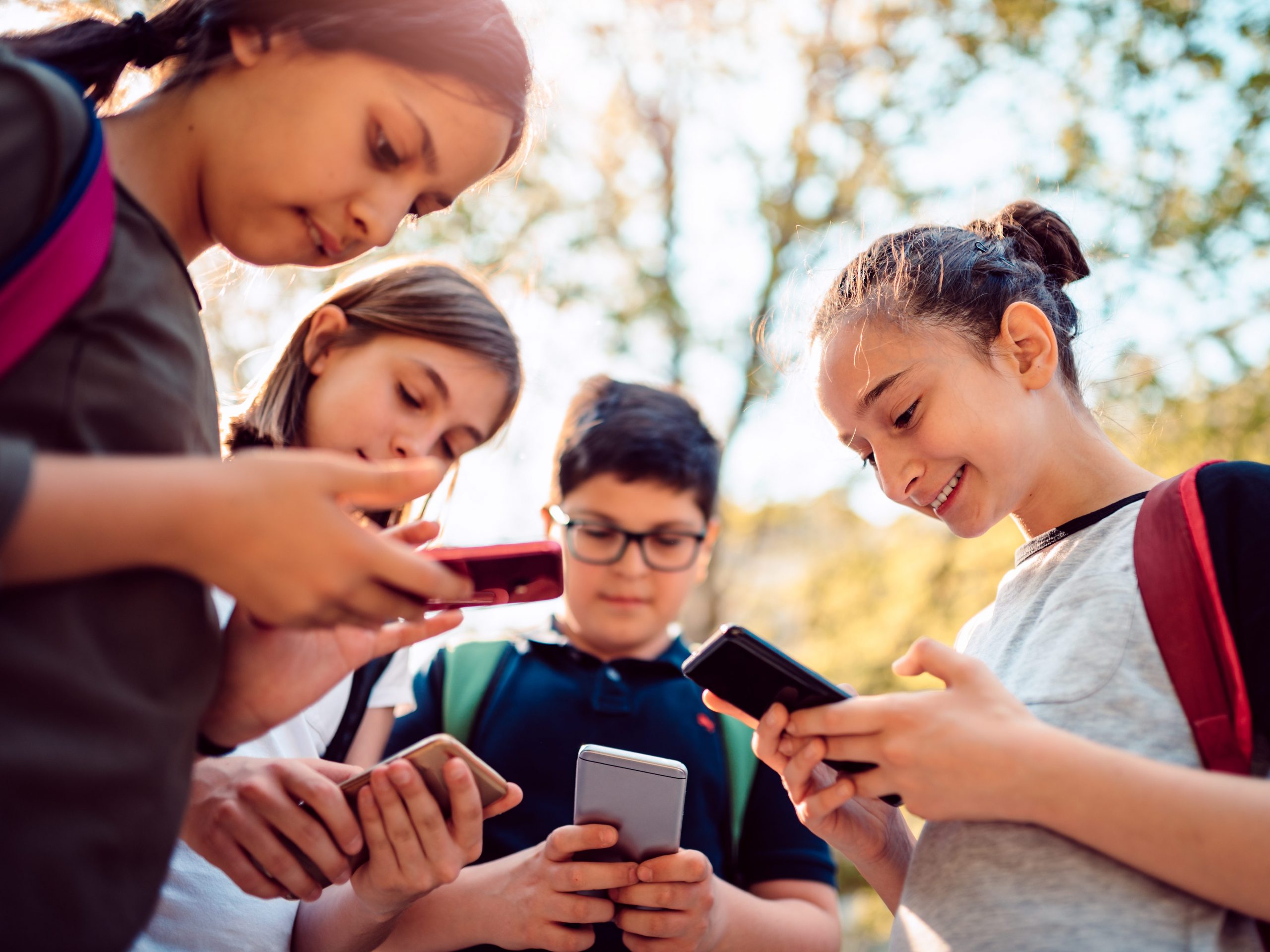 Kids using social media on smart phone after school