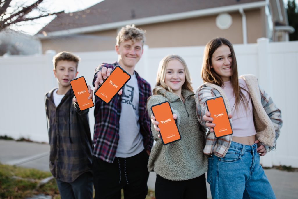 4 kids holding troomi phones
