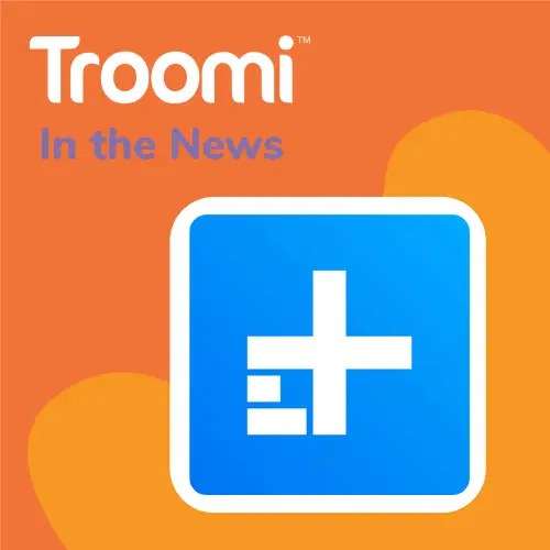 Orange background with Troomi and In the News text in the top left corner. A large blue square with a white geometric design is centered. An abstract orange heart shape is partially visible, highlighting Troomi's safety features as discussed in Digital Trends.