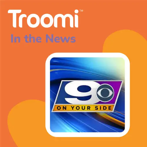 Orange background with the text "Troomi In the News" at the top. Below is a bordered square featuring a news logo with "9 On Your Side" on a vibrant blue and purple background, highlighting a limited experience that will grow with your child.