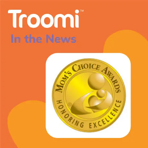 An orange background displays the Troomi logo with "In the News" beneath it. Beside it, the Mom's Choice Awards gold emblem shines, proudly announcing: Troomi Wins a Mom’s Choice Award! Honoring Excellence.