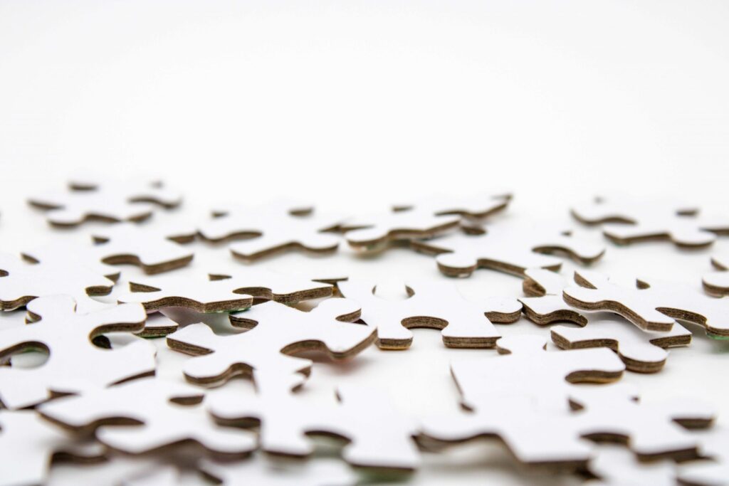 A close-up shot of scattered white puzzle pieces on a white background, reminiscent of puzzles for kids, invites the joy and challenge of piecing together a world in miniature.