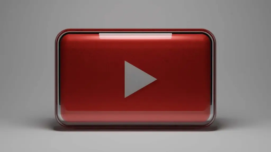 A 3D red and silver play button symbol, reminiscent of the YouTube logo, is set against a neutral gray background, evoking the fun and discovery found on the best educational YouTube channels for kids.