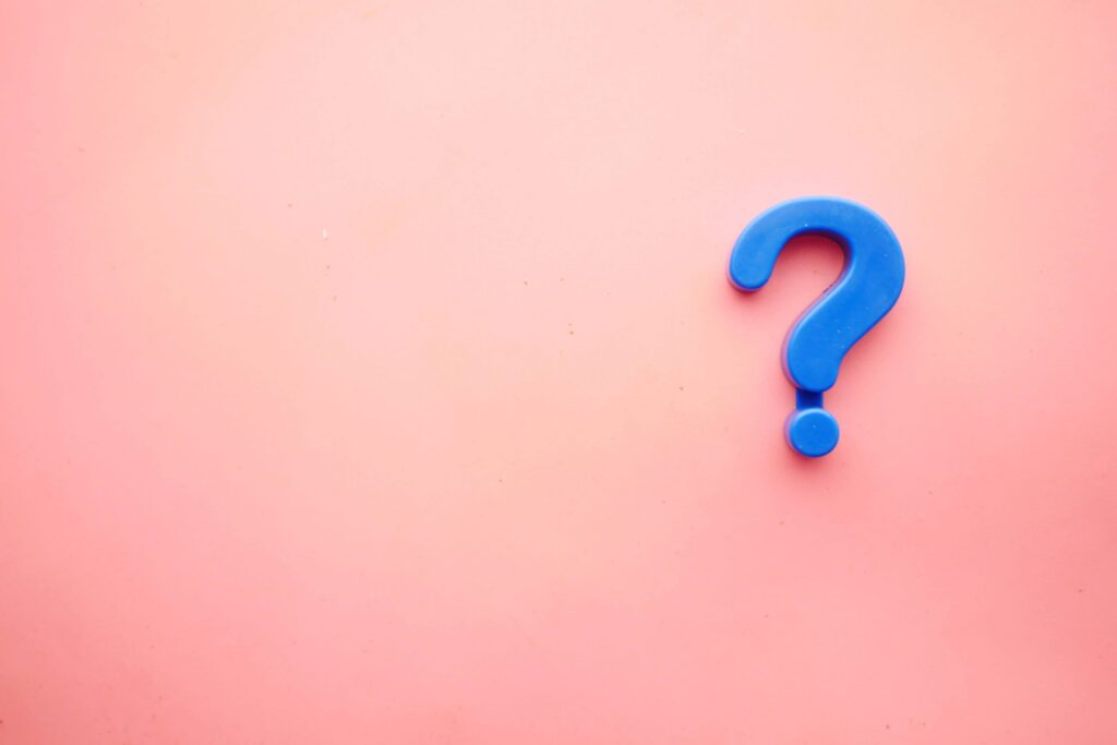 A large blue question mark, reminiscent of playful kids' movie trivia, is positioned on the right side of a plain pink background.