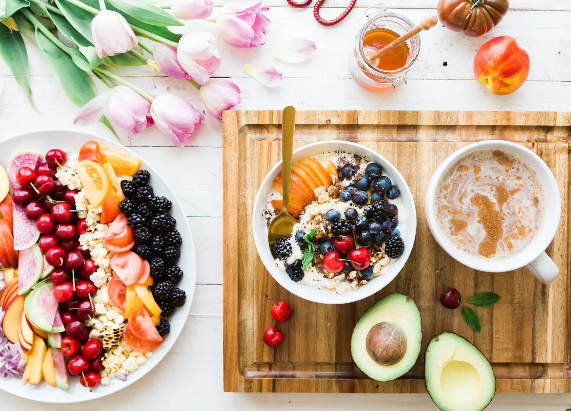 oatmeal with fruit next to a hot drink and an avacado