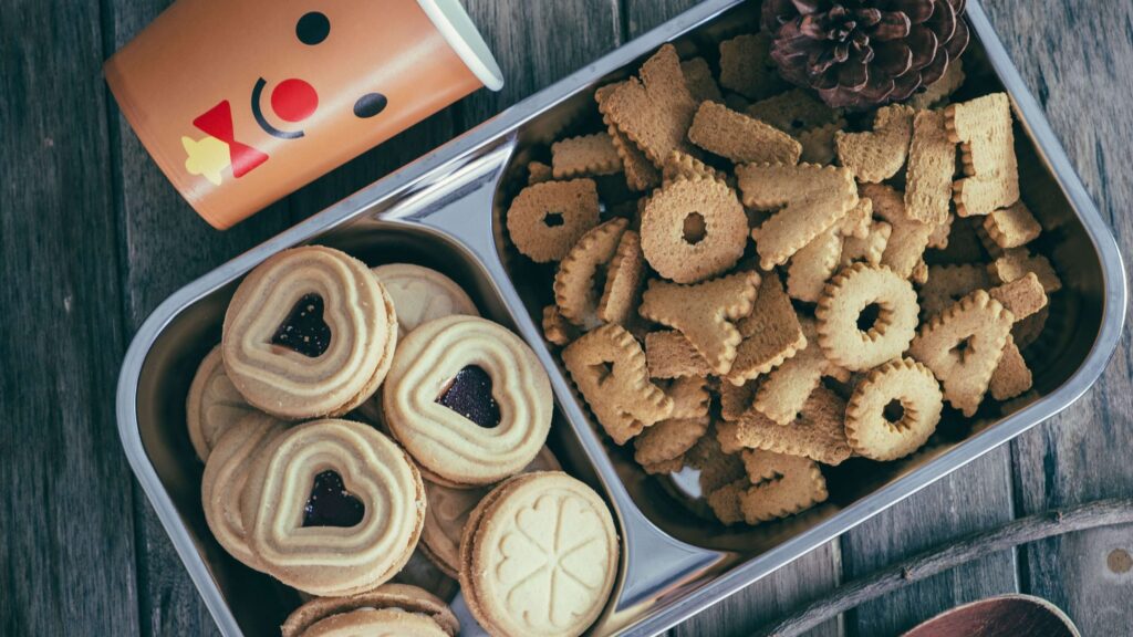 three types of sugar cookies in a tin container