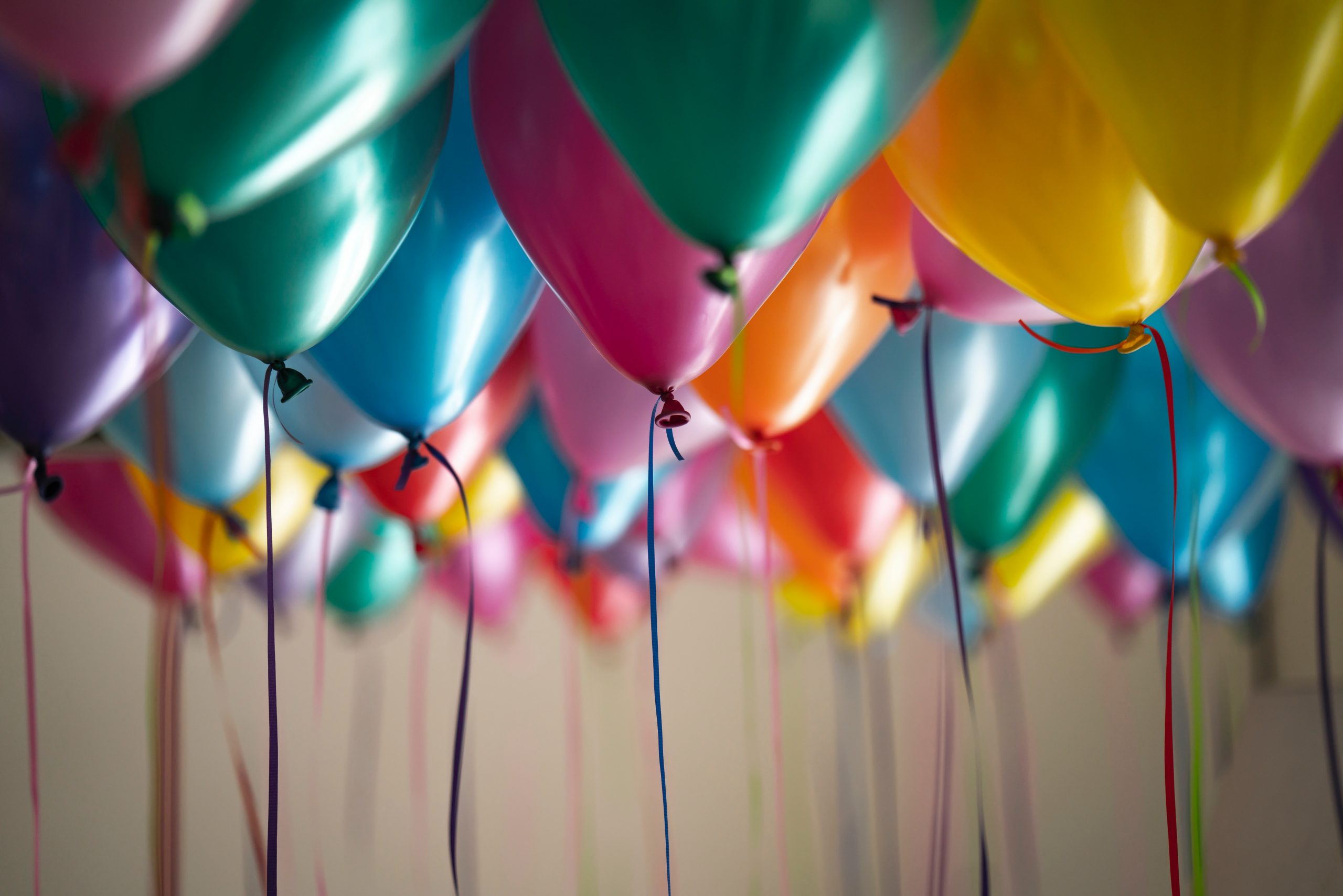 a room full of colorful balloons with strings