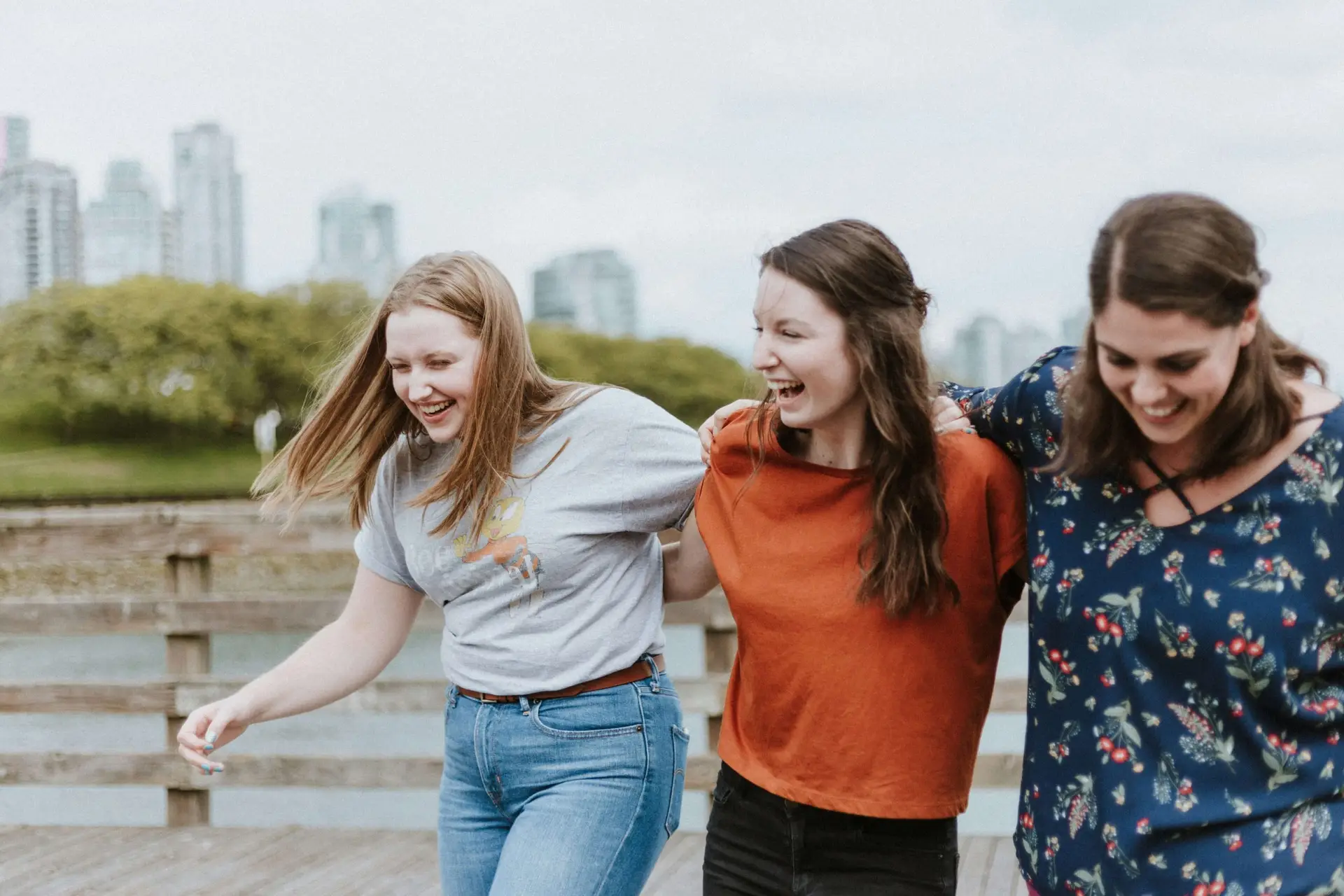 three women holding each other and walking