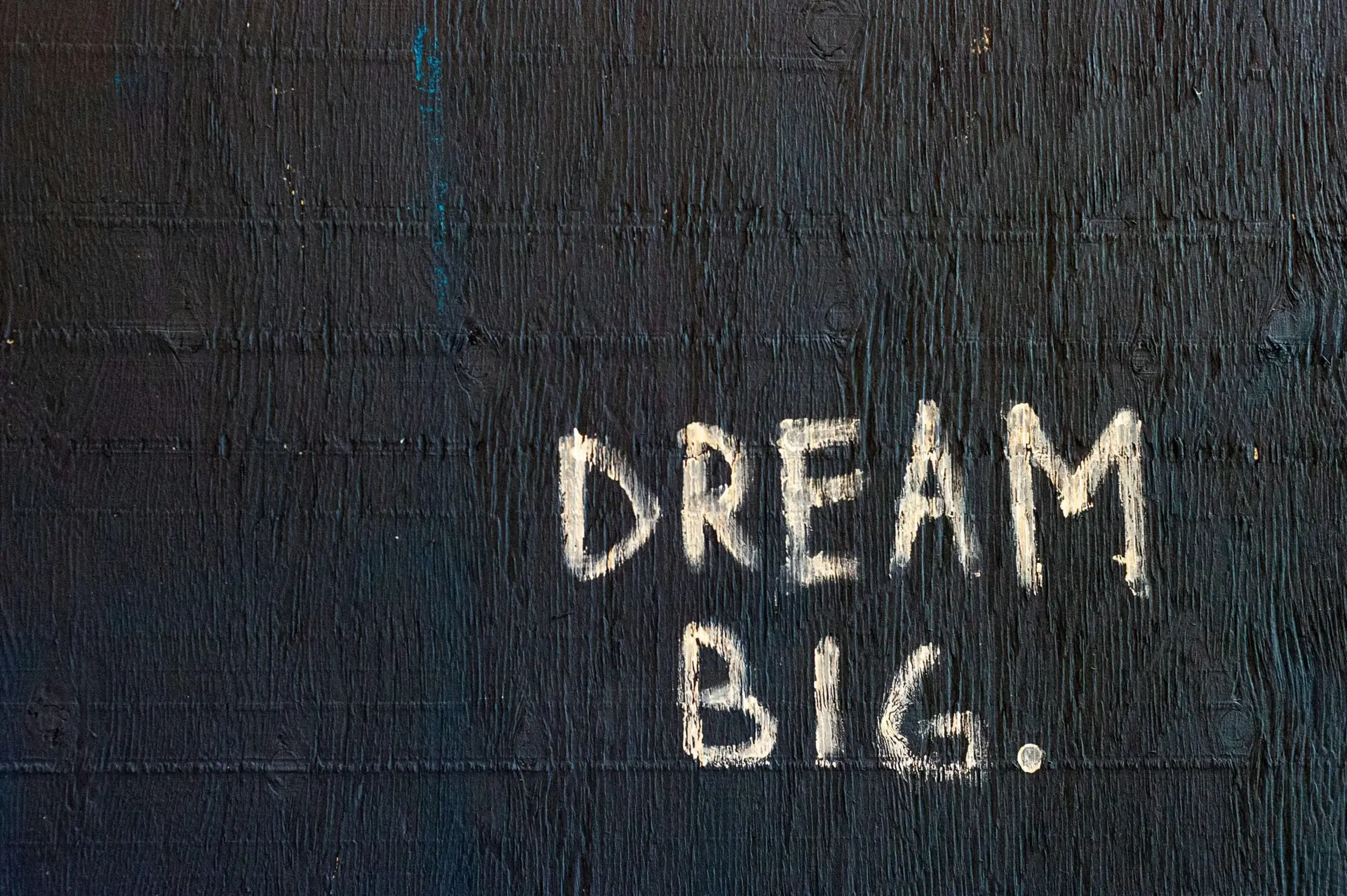 black wall with dream big written in white