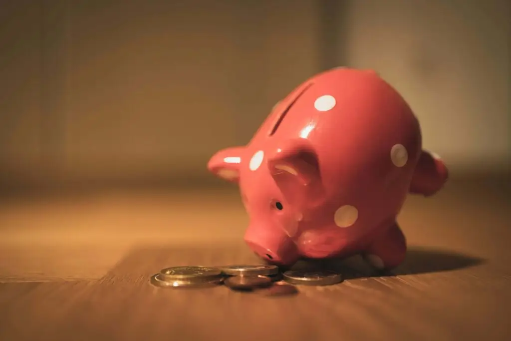 pink and white piggy bank with coins