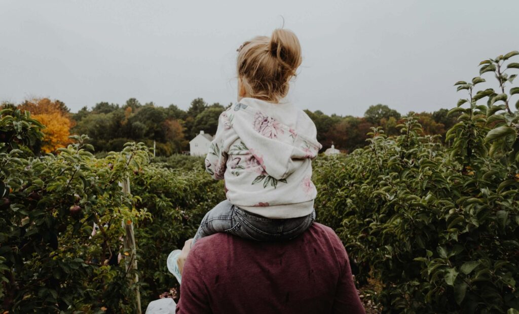 daughter on her parents shoulders