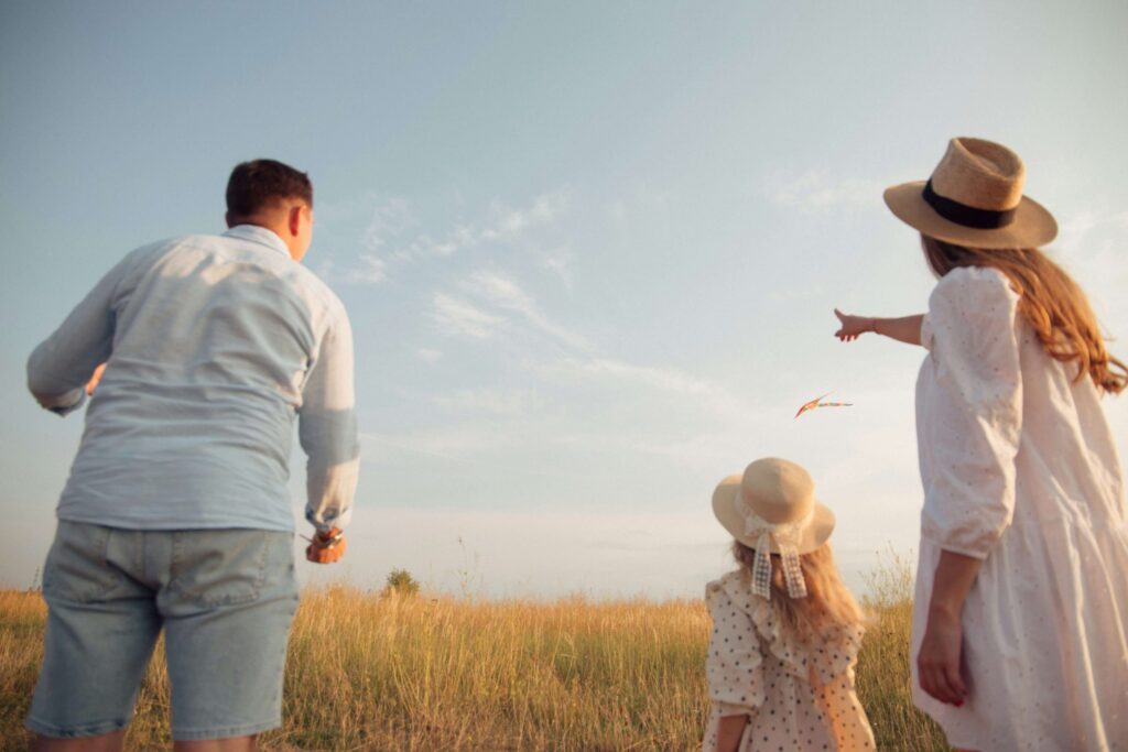 mom and dad with their daughter flying a kite