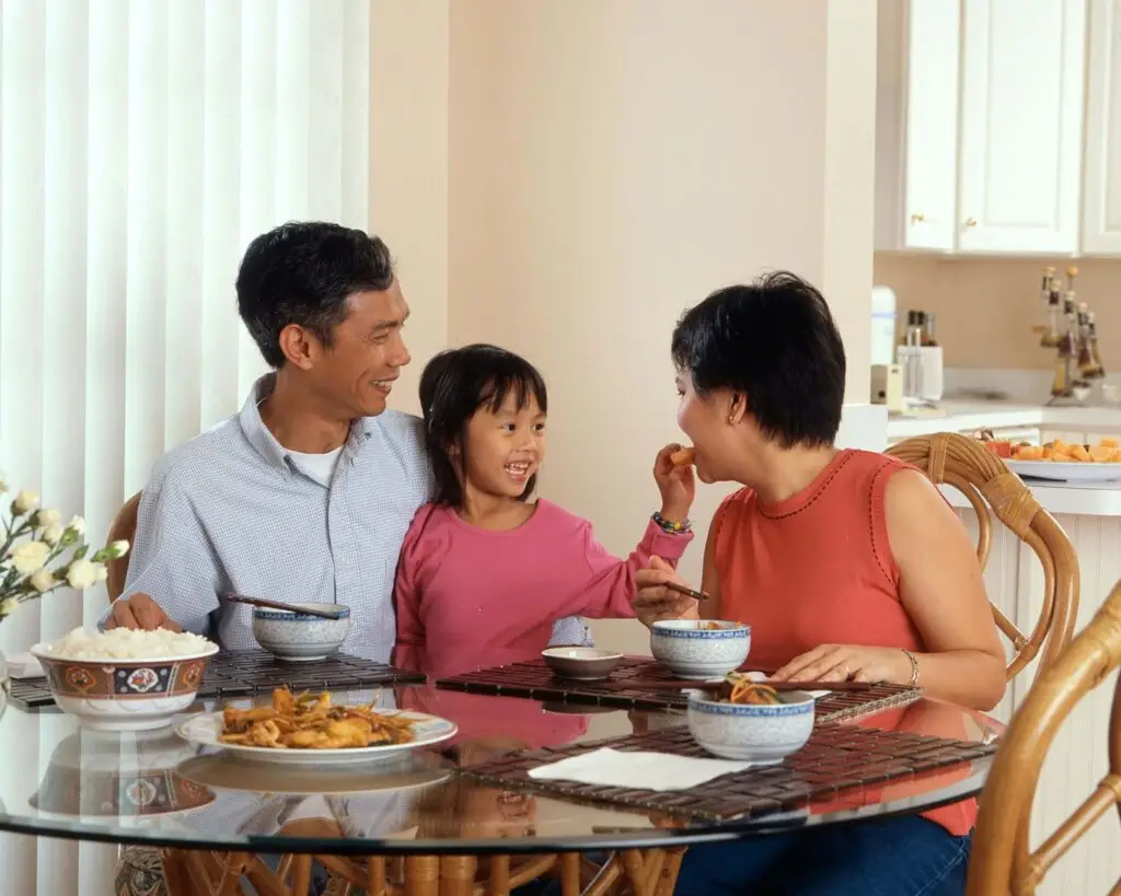 daughter sharing her food with her mom at the dinner table