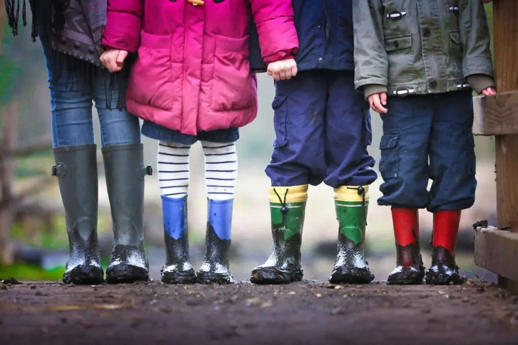 kids in their rainboots outside in the mud