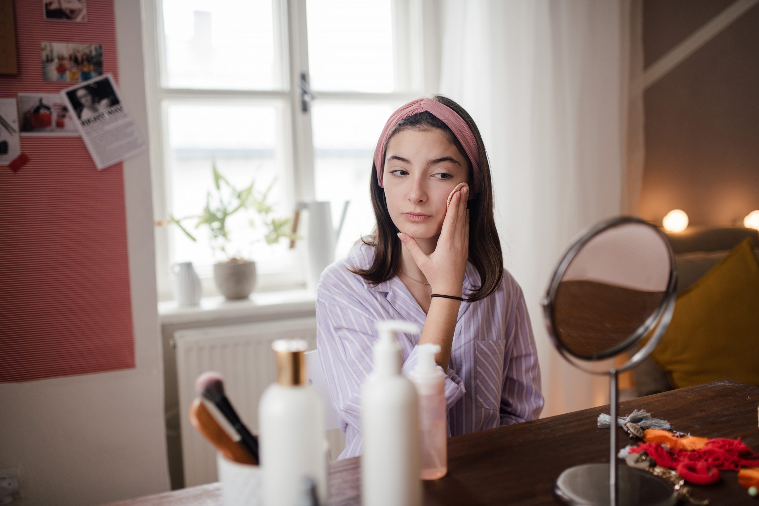 Teenage girl doing her skin care routine in the room.