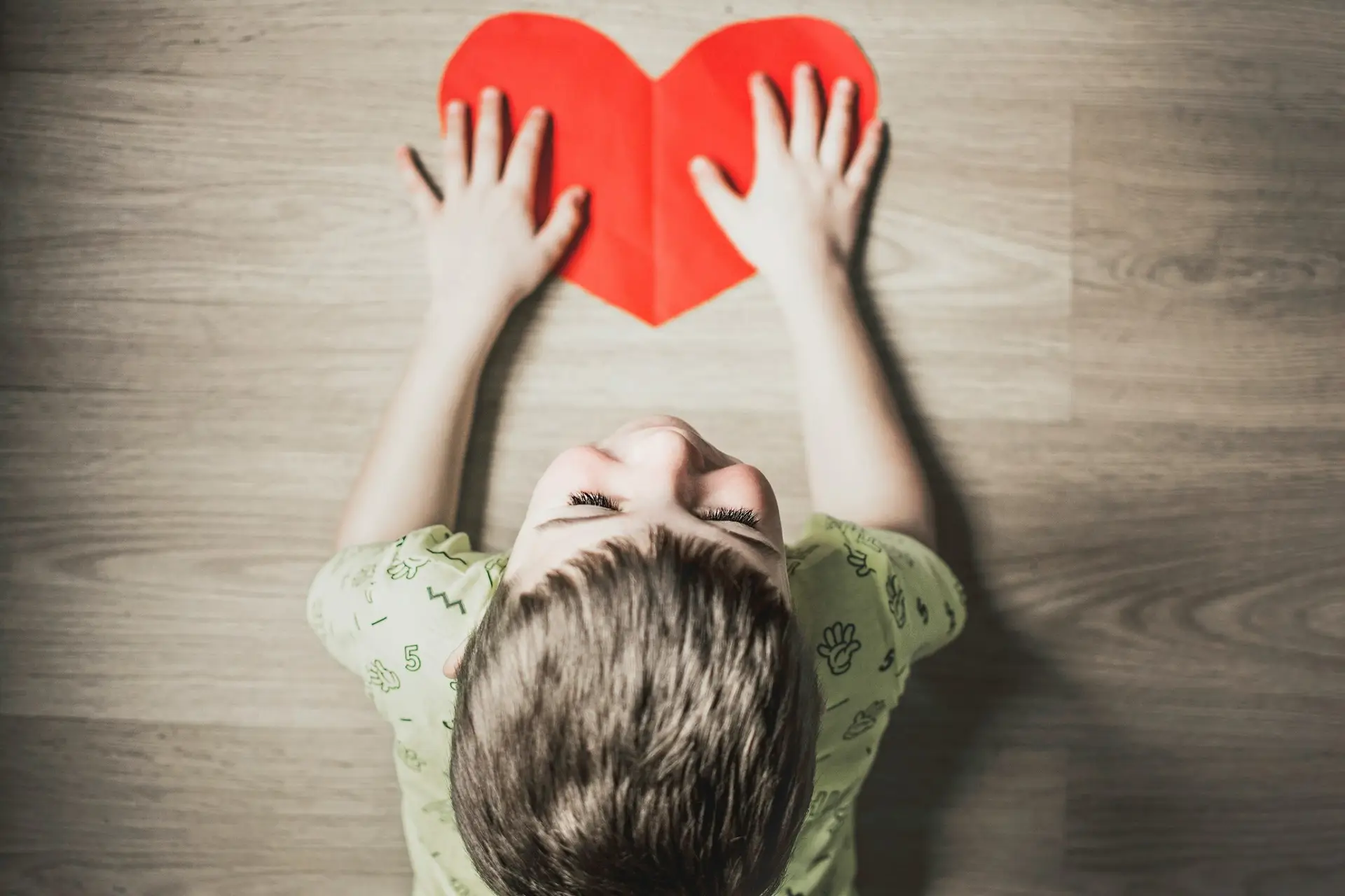 kid holding red paper heart