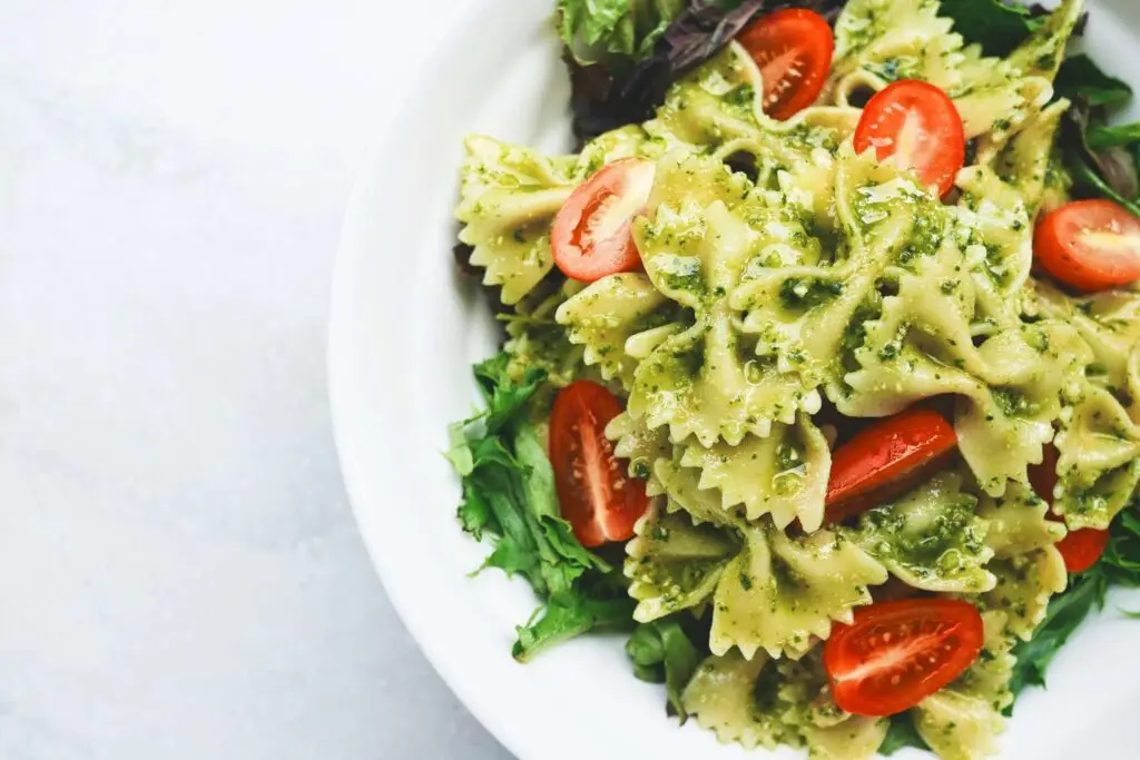 close up of pesto pasta with tomatoes