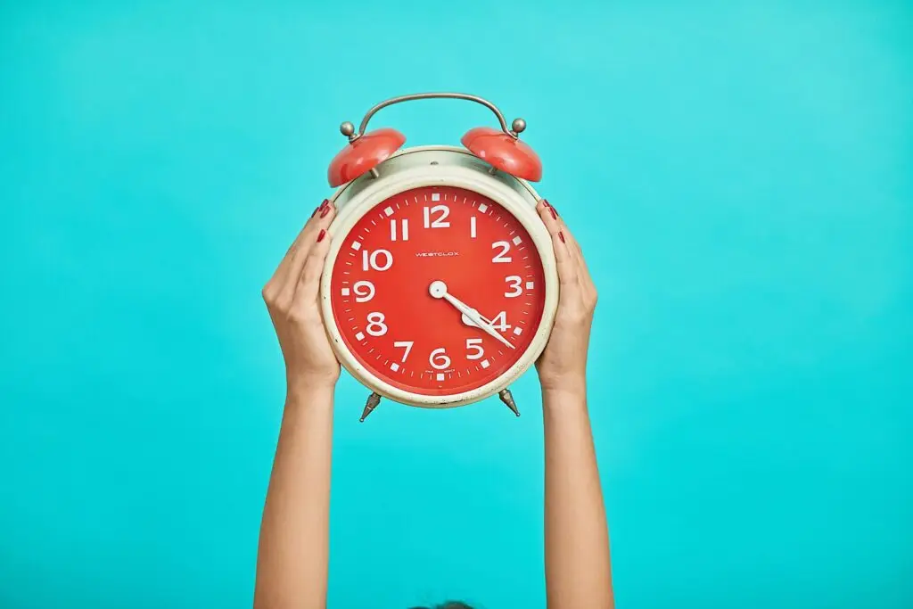 person holding a red clock above them