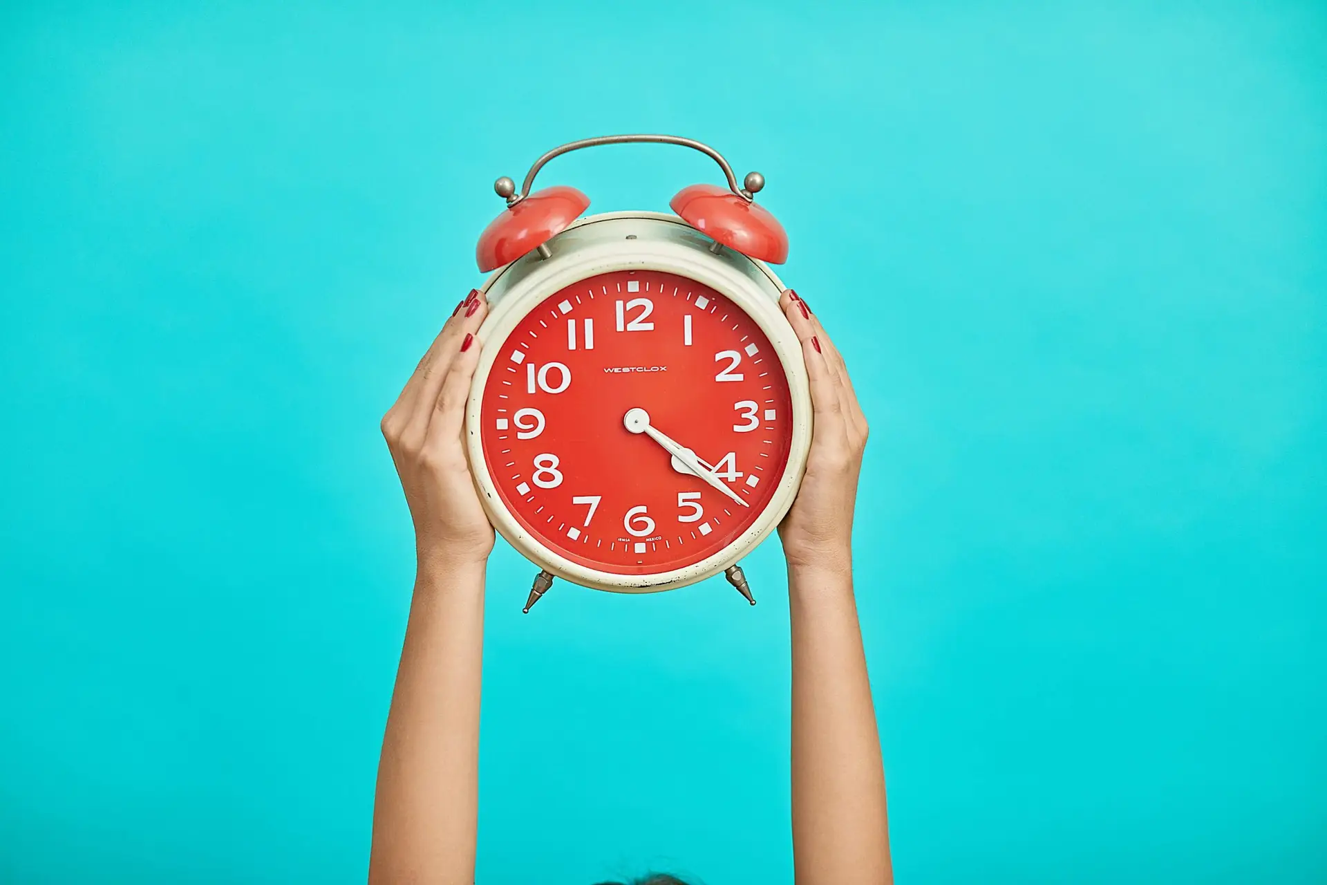 person holding a red clock above them