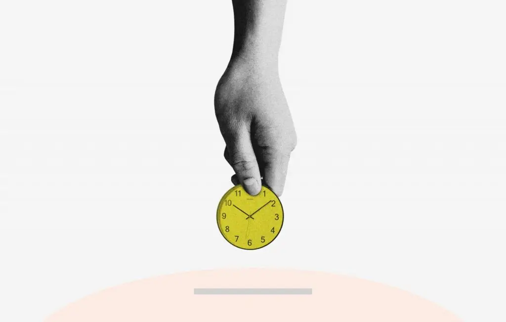 person holding small yellow clock