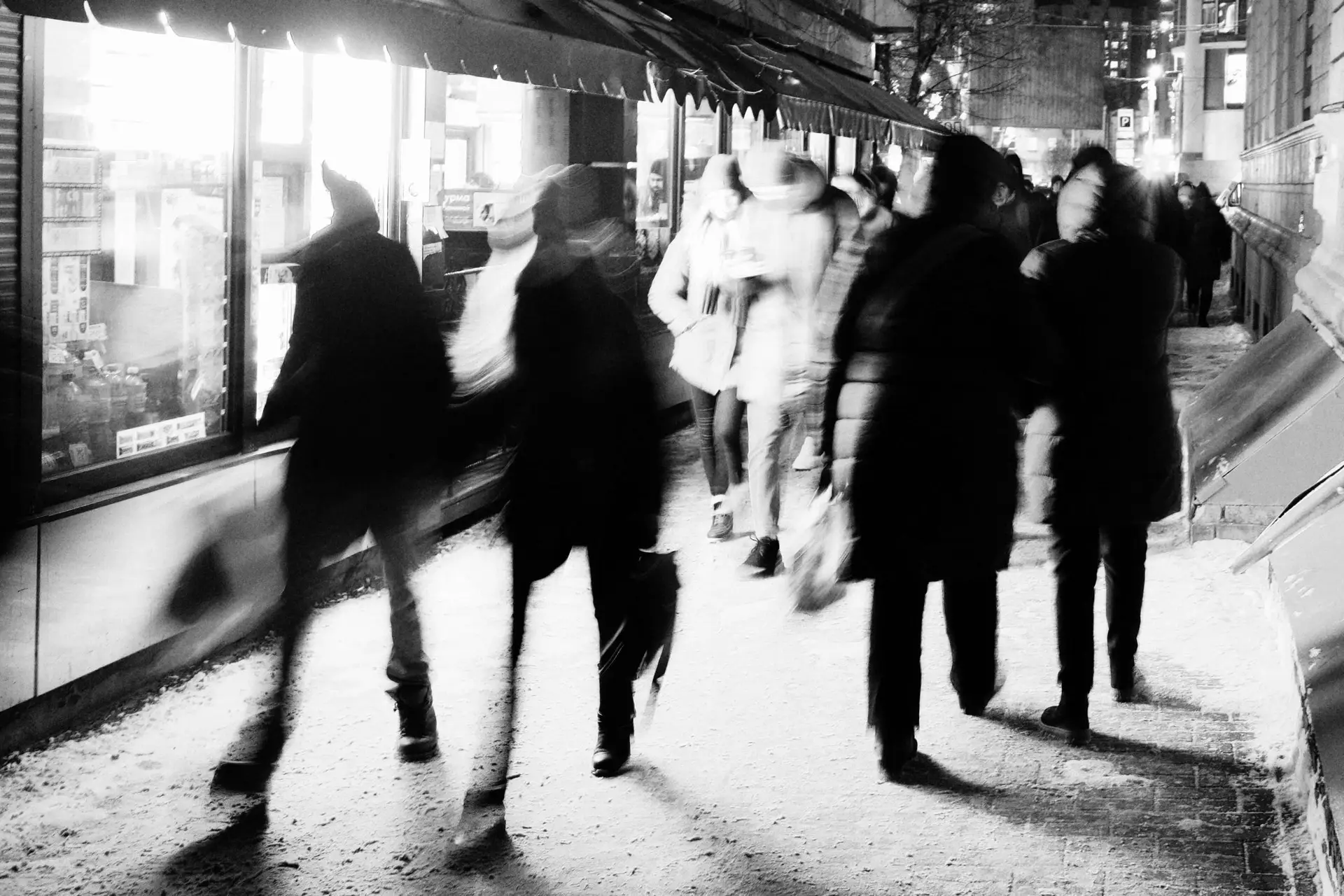 black and white photo of people walking in a city