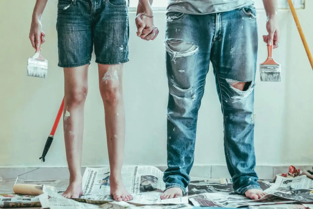 couple covered in paint after painting their house