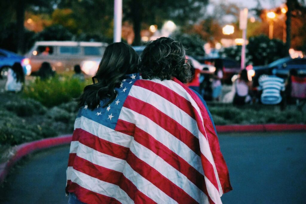 two people with the american flag wrapped around them