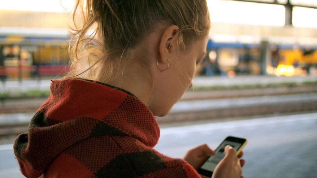 teenage girl using a smartphone outside