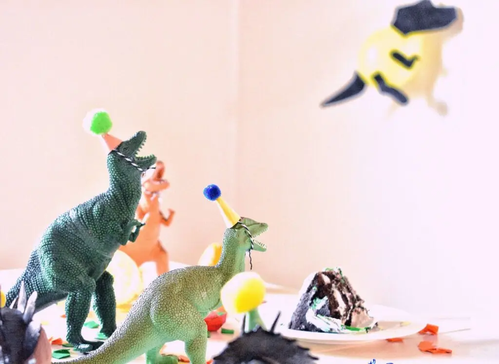 mini toy dinosaurs with birthday hats on