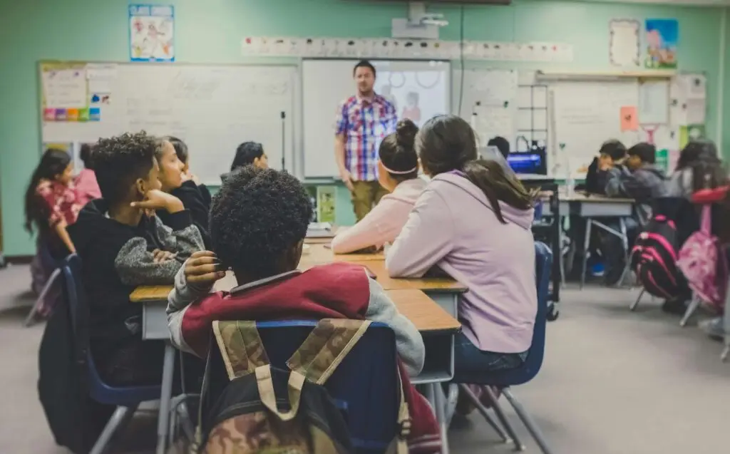 kids in classroom listening to their male teacher