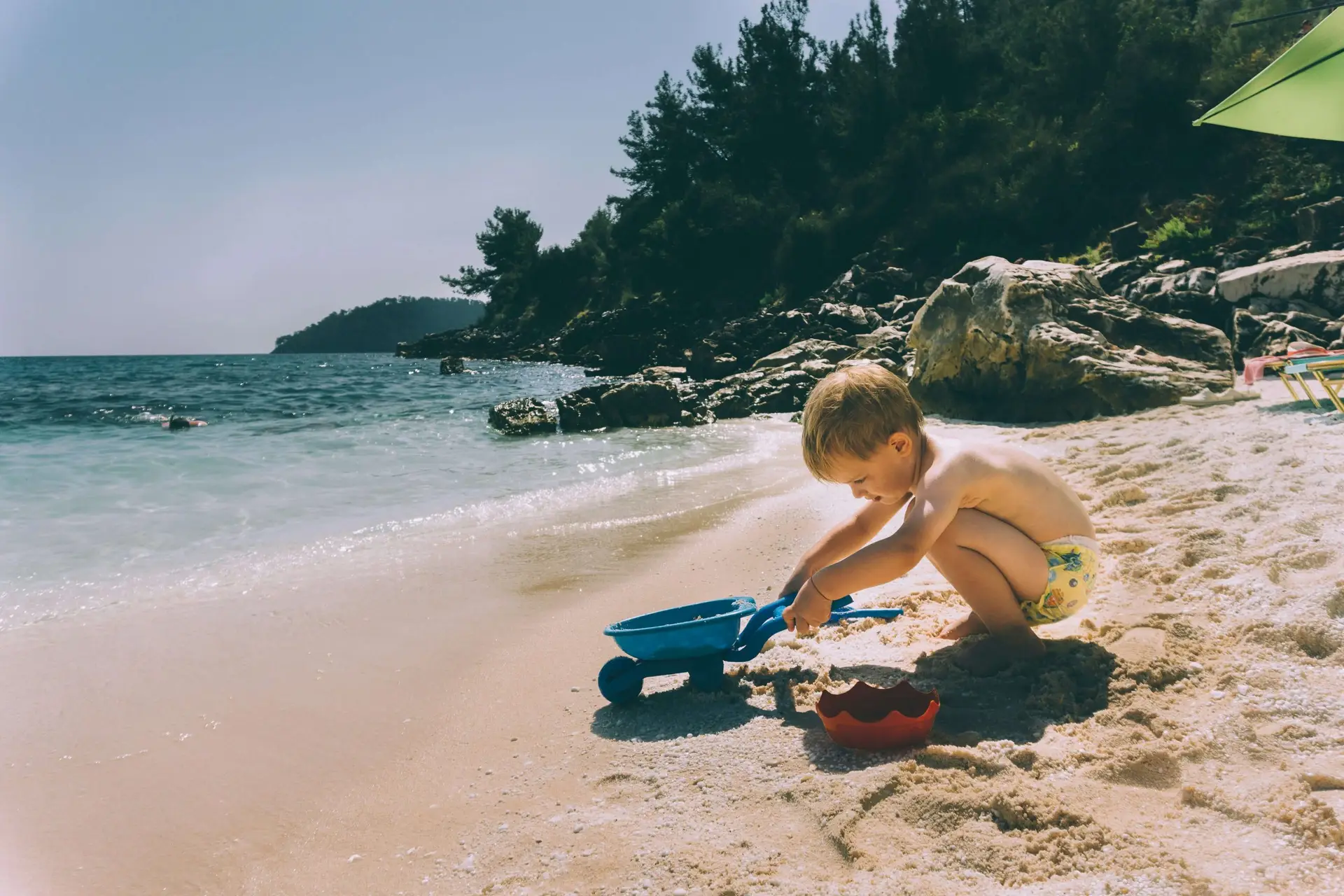 little boy playing in the sand at the beach