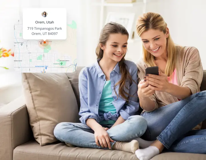 A woman and a girl sit on a couch, smiling while looking at a smartphone. A transparent overlay shows a map with a location pin in Orem, Utah, and the address 719 Timpanogos Park, Orem, UT 84097.