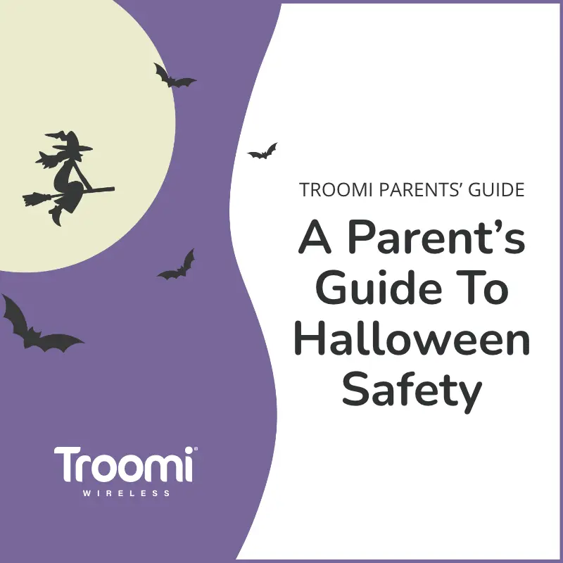 Illustration with a purple background featuring a witch on a broomstick and bats flying around a full moon. Text reads: Troomi Parents Guide: A Parent’s Guide to Halloween Safety with the Troomi Wireless logo. Explore our downloadable resources for more safety tips.