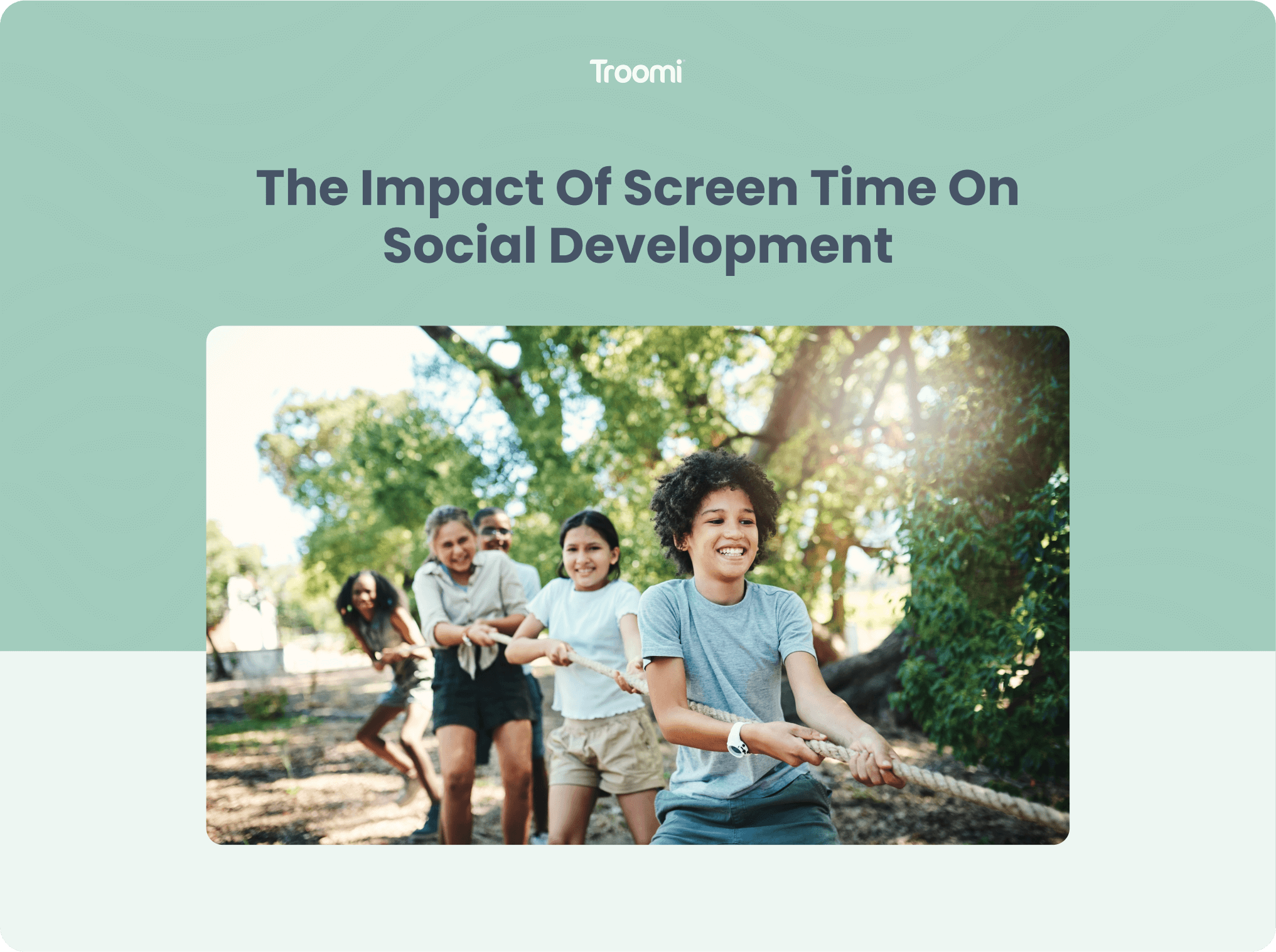 Children playing tug-of-war outdoors, smiling and pulling a rope. The background features trees and sunlight filtering through. Text above reads, The Impact of Screen Time on Social Development, with the Troomi logo at the top.