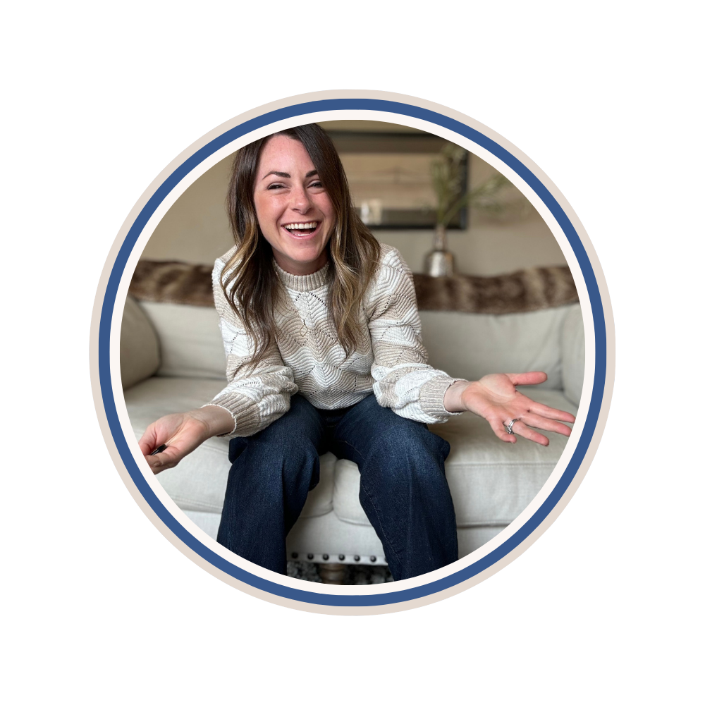 A woman with long brown hair sits on a white sofa, smiling and leaning forward with her hands open in a friendly gesture. She wears a light sweater and dark jeans. The image is framed by concentric blue and white circles.