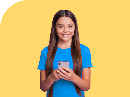 Smiling girl with long brown hair wearing a blue shirt holds a smartphone in both hands, standing in front of a yellow background.