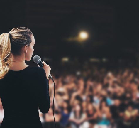 Donna con microfono su palco pubblico
